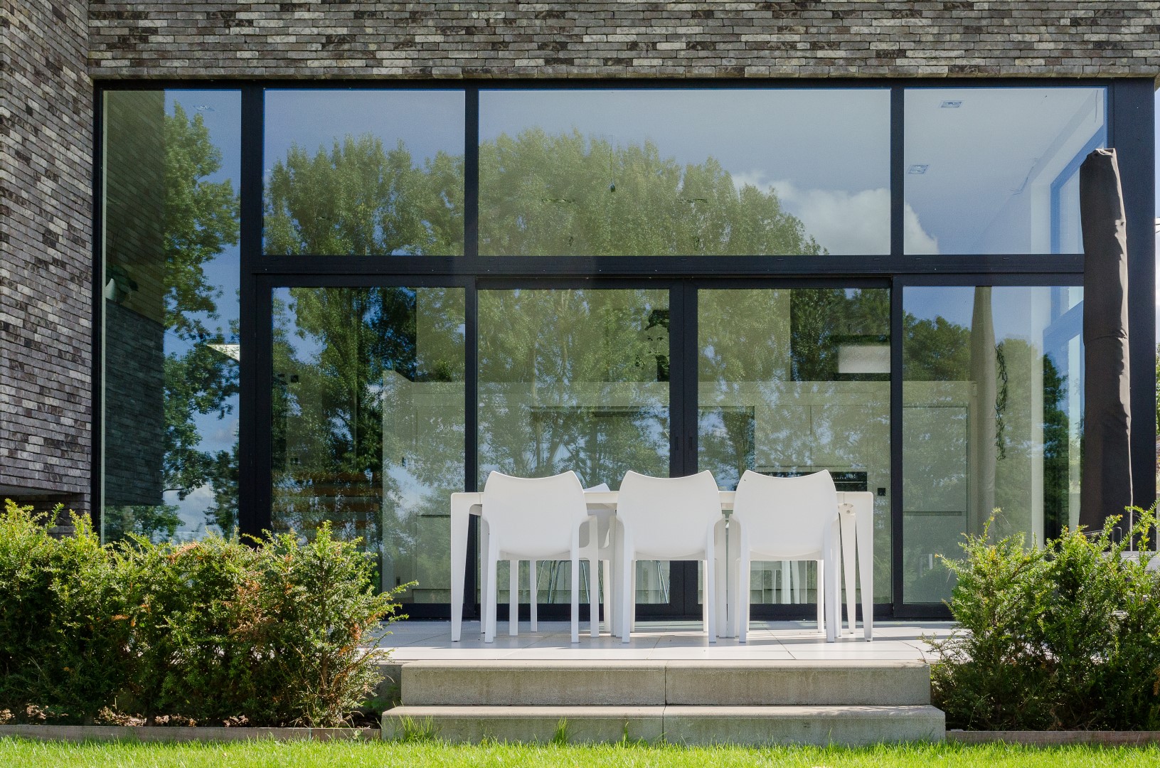 Detail panoramisch raam aan de achterzijde van de strakke woning in Herfelingen