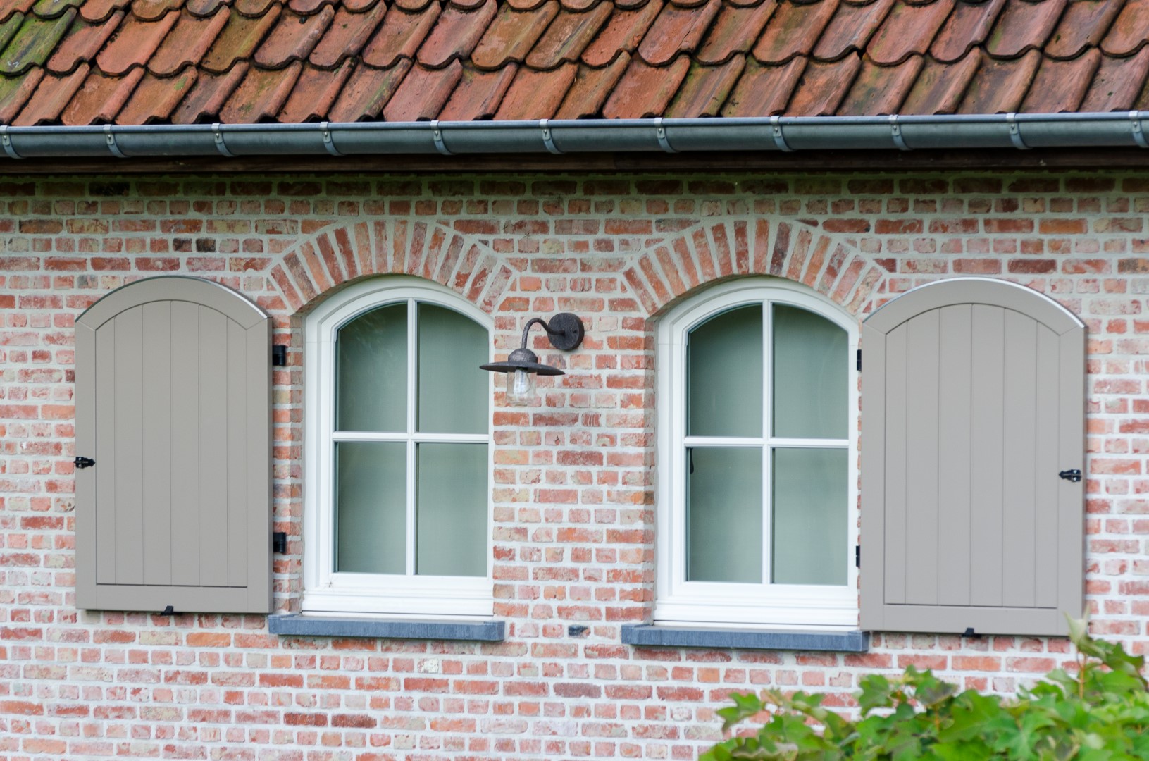 Detail gebogen ramen met luiken pastorijwoning met landelijke elementen