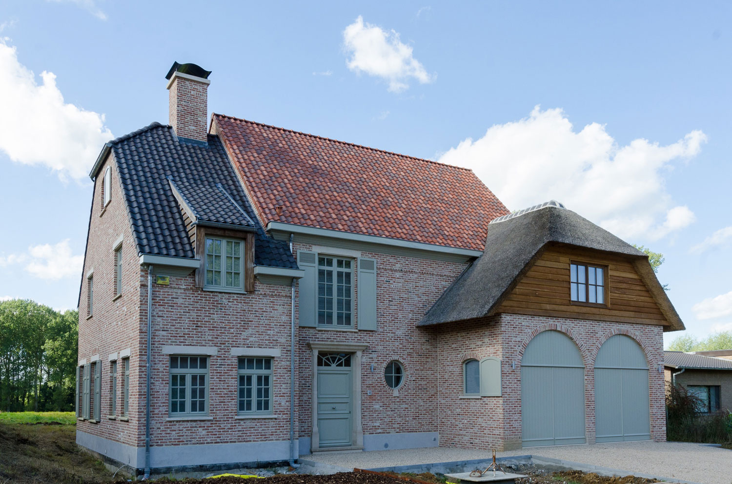 De landelijke accenten zoals hout, dakkapellen, luiken, rieten dak en gebogen ramen zorgen voor een authentieke look Voorkant gevel karaktervolle, landelijke nieuwbouw
